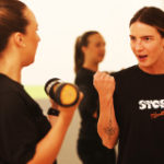 Elite pathway - trainer explaining use of weight in arm exercise